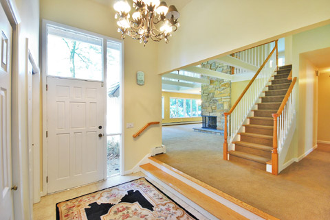 Foyer leads into living room and dining room adjoined by stone fireplace two stories high!