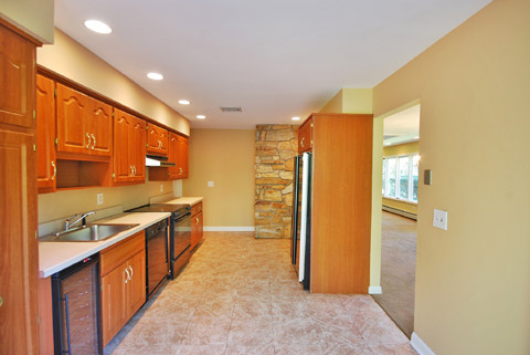 Open kitchen layout with ample cabinet space and beautiful tile flooring.